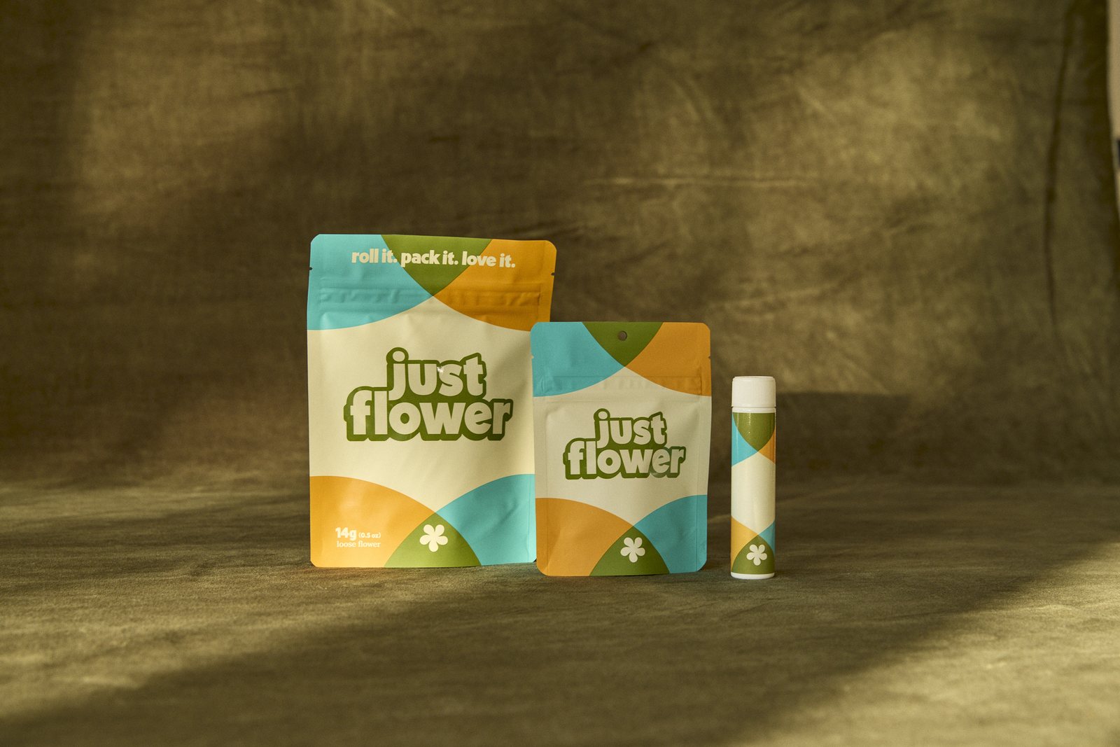 Lineup of Just Flower cannabis packages and a pre-roll tube on an olive backdrop