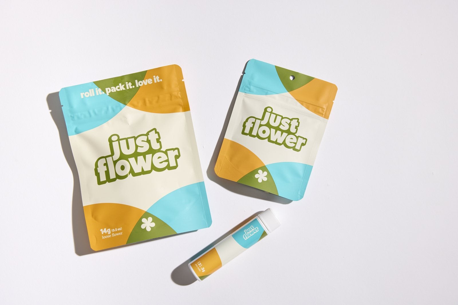 Just Flower 14g and 3.5g packages with a pre-roll tube on a white background